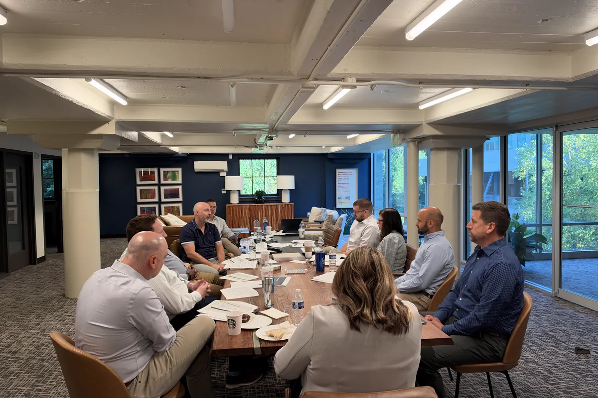 Helion Technologies team members meeting around a long conference table in a bright office